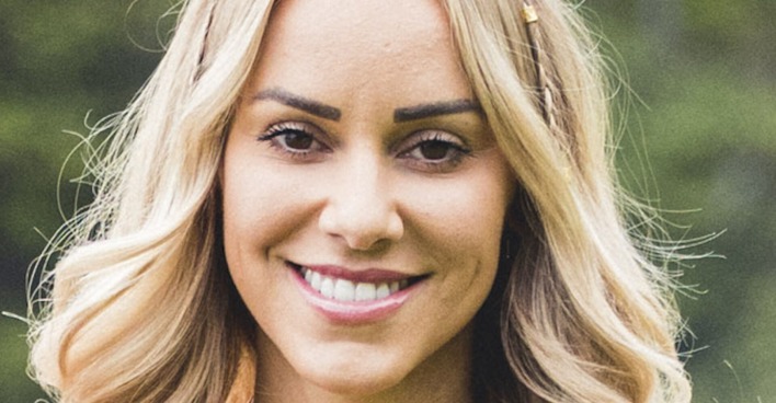 Vanessa Mariposa lächelt mit offenen blonden Haaren in die Kamera.