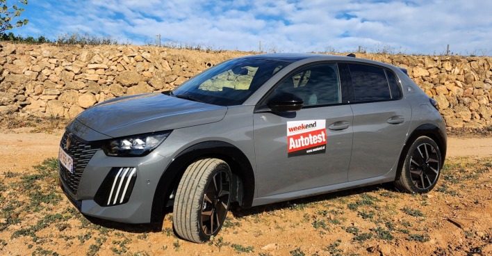 Der Peugeot E 208 vor einer Steinmauer