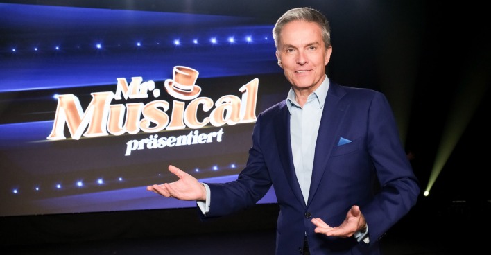 Alfons Haider vor dem Bildschirm zur Show "Mr.Musical"