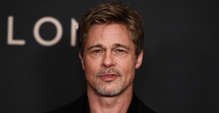 Brad Pitt vor einer schwarzen Fotowand.
