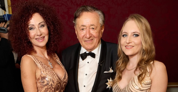 Christine Lugner trägt ein goldenes Kleid und offene Haare, Richard Lugner einen Smoking und Jacky Lugner ein Ballkleid und offene blonde Haare.