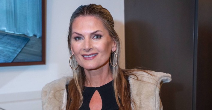 Martina Kaiser mit einem schwarzen Kleid und beigem Mantel.