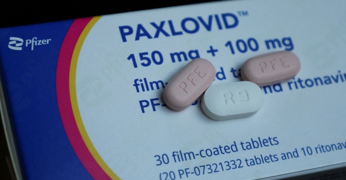 Eine Packung Paxlovid und drei einzelne Tabletten.