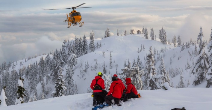 Rettungskräfte und Helikopter bei einem verunfallten Skifahrer.