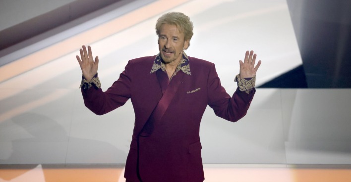 Thomas Gottschalk trägt einen dunkelroten Anzug.