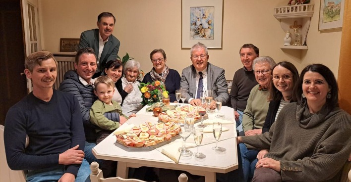 Menschen sitzen um den Tisch, um Geburtstag zu feiern
