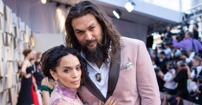Jason Mamoa und Lisa Bonet in rosa Outfits auf dem roten Teppich.