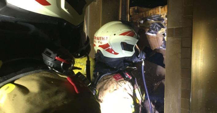 Zwei Feuerwehrmänner dringen zu einem Saunabrand vor.