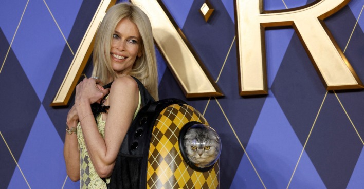 Claudia Schiffer auf dem roten Teppich mit einer Katze im Rucksack.