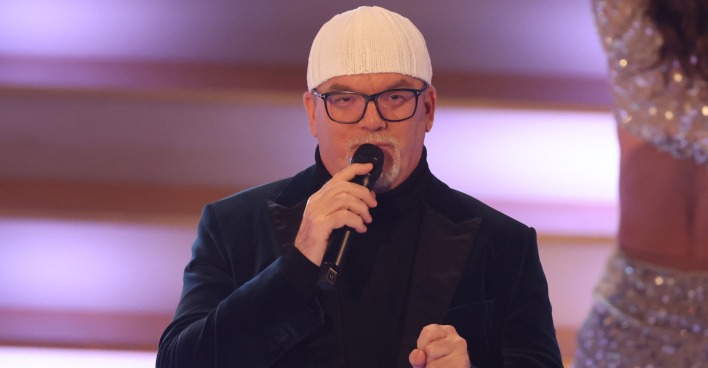 DJ Ötzi auf der Bühne mit einer weißen Mütze und einem schwarzen Sakko.