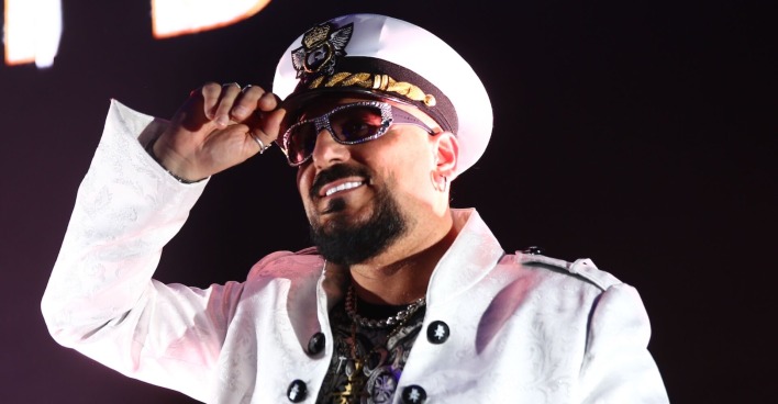 Gigi D'Agostino mit einem weißen Hut und einem weißen Sakko.