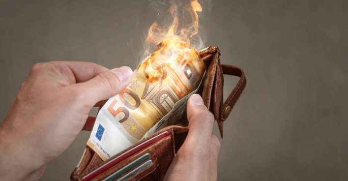 Eine Mann öffnet eine Geldtasche. Der 50-Euro-Schein darin brennt