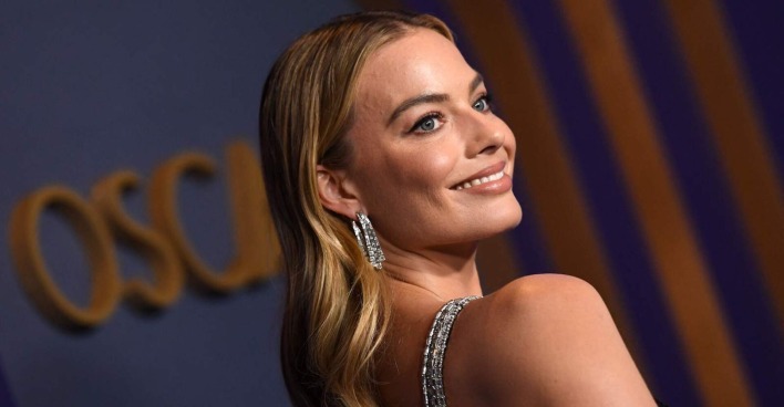 Margot Robbie bei den Oscars. Sie trägt offene blonde Haare und Diamantenohrringe.