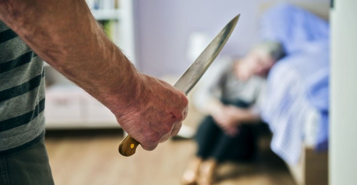 Ein Mann bedroht eine Frau mit einem Küchenmesser