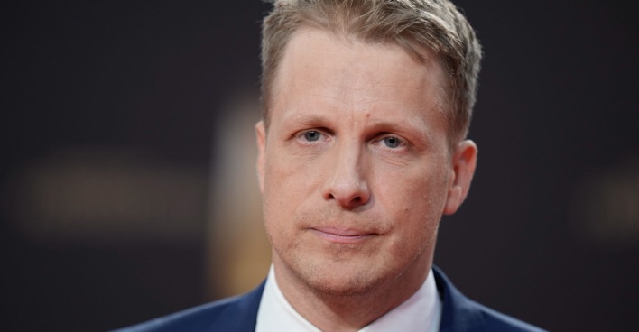 Oliver Pocher mit einem ernsten Gesichtsausdruck und einem Anzug.
