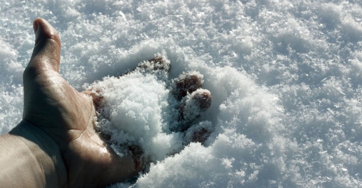 Eine gefrorene Hand im Schnee.