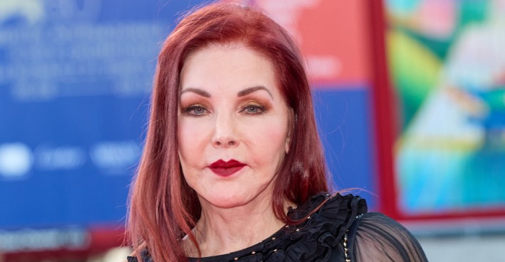 Priscilla Presley mit roten, offenen Haaren und roten Lippenstift.