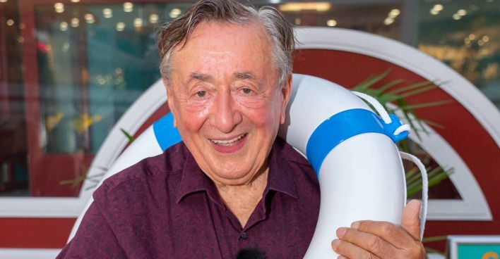 Richard Lugner mit einem dunkelroten Hemd und einem Rettungsreifen.