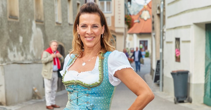 Sabine Petzl mit hochgesteckten Haaren und in einem blauen Dirndl.