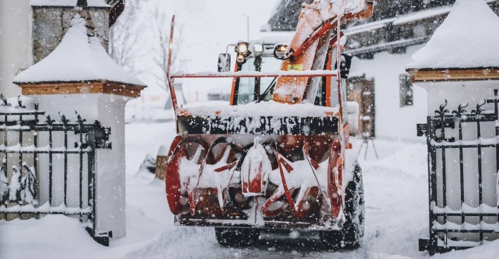 Eine Schneefräse fährt durch ein Tor.