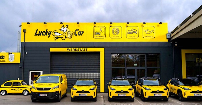 Fahrzeugflotte vor gebrandeter Werkstatt