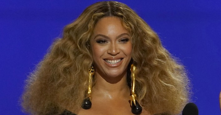 Beyoncé mit offenen, voluminösen Haaren auf einer Tribüne.