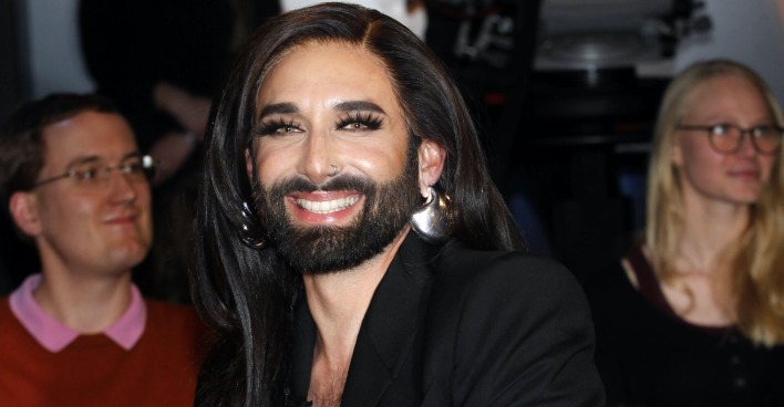 Conchita Wurst mit offenen langen schwarzen Haaren bei einem Event.