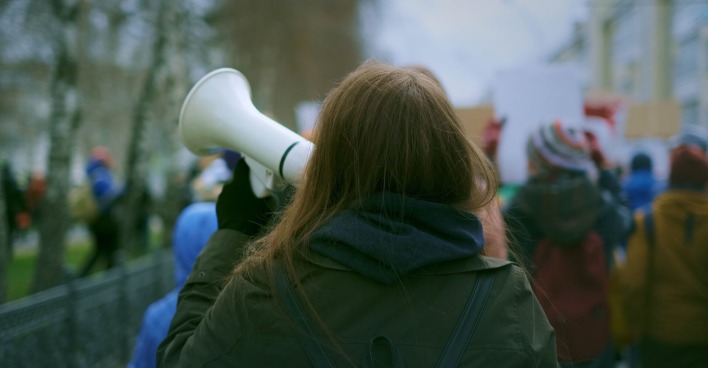 Eine Demonstrantin mit einem Megaphon.