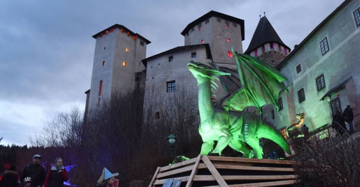 Leuchtender Drache befindet sich in anmutiger Haltung vor der Burg Lockenhaus im Burgenland