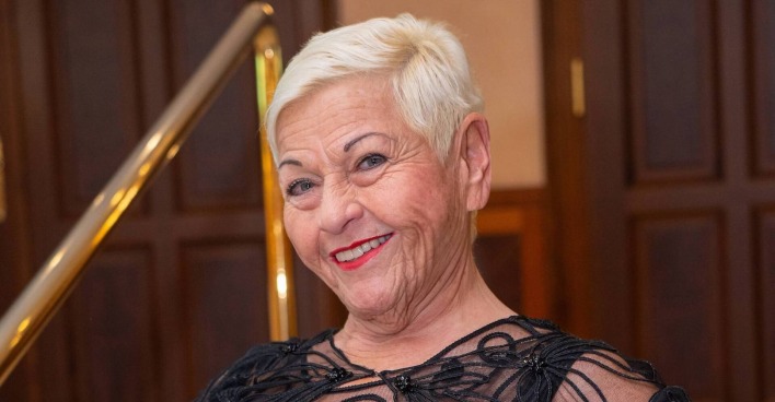 Jazz Gitti mit kurzen blonden Haaren und einem schwarzen Kleid.