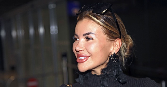 Kim Virginia mit zusammen gebundenen Haaren, einer Sonnenbrille und einem schwarzen Pullover.
