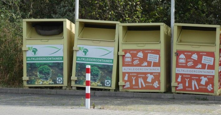 Vier Altkleidercontainer nebeneinander.