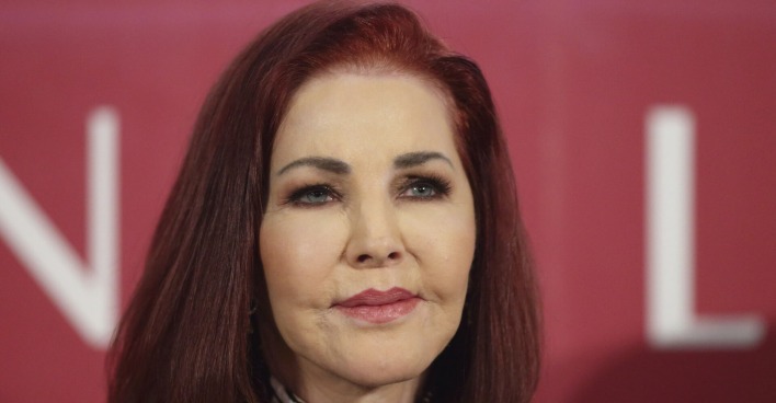 Priscilla Presley mit roten offenen Haaren bei einer Pressekonferenz.