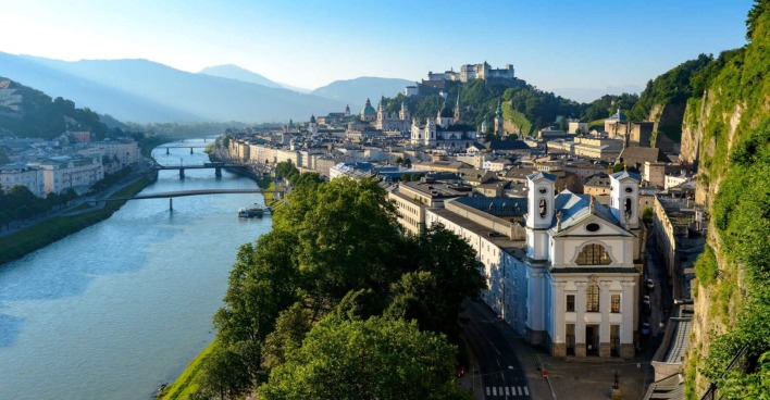 Die Stadt Salzburg mit Blick auf die Salzach und die Festung bei Sonnenaufgang.