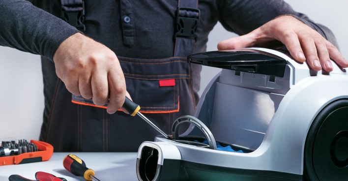 Handwerker repariert grauen Staubsauger | Credit: Sergei Chuyko/istock.com