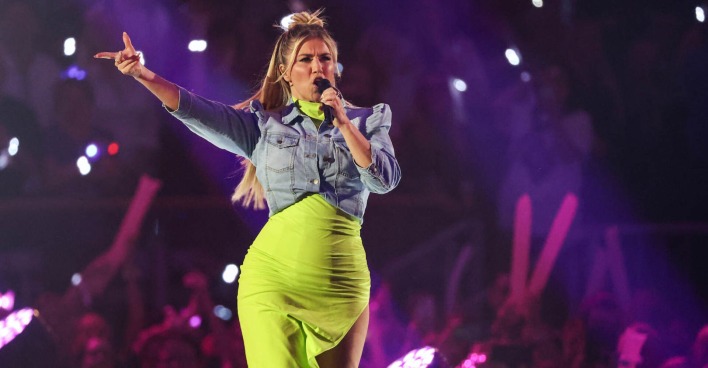 Beatrice Egli mit einem Neongelben Kleid und einer Jeansjacke.
