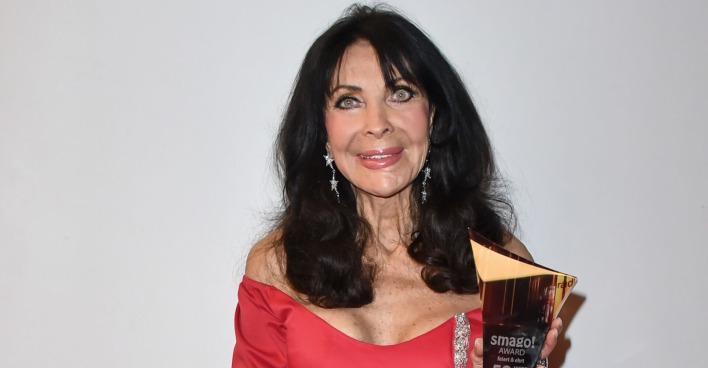 Dunja Rajter mit einem roten Kleid und offenen schwarzen Haaren.