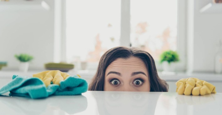 Frau, die über den Küchentresen lugt. Es ist ihr Kopf zur Hälfte zu sehen.