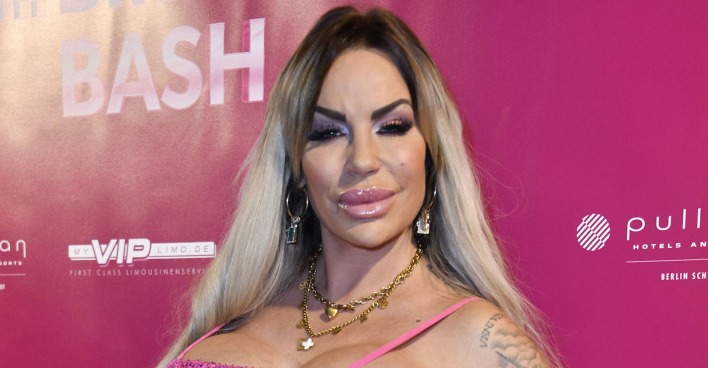 Gina Lisa Lohnfink vor einer pinken Fotowand.