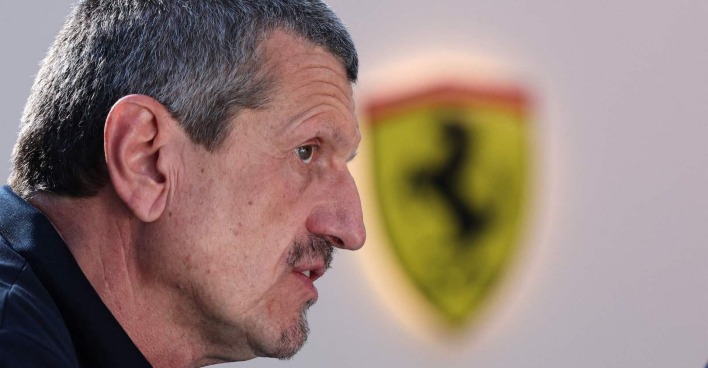 Guenther Steiner in Großaufnahme im Profil, im Hintergrund das Logo von Ferrari