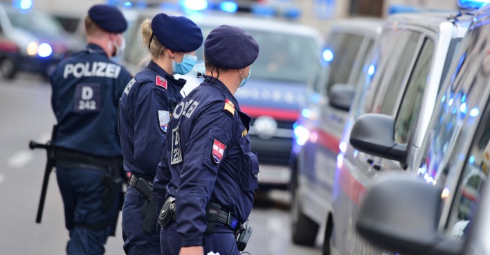 Polizisten gehen auf ihre Einsatzfahrzeuge zu