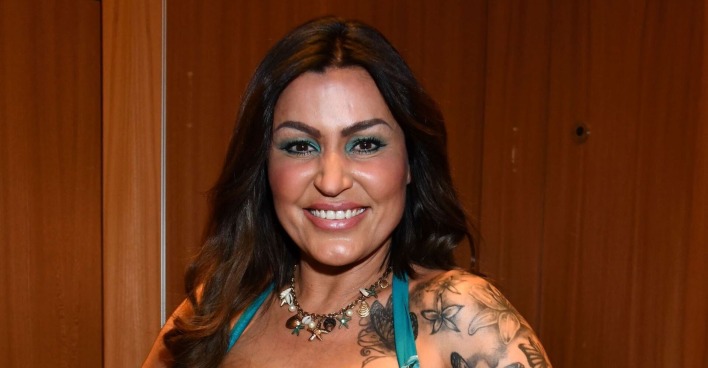 Jasmin Herren mit offenen braunen Haaren und Tattoos.