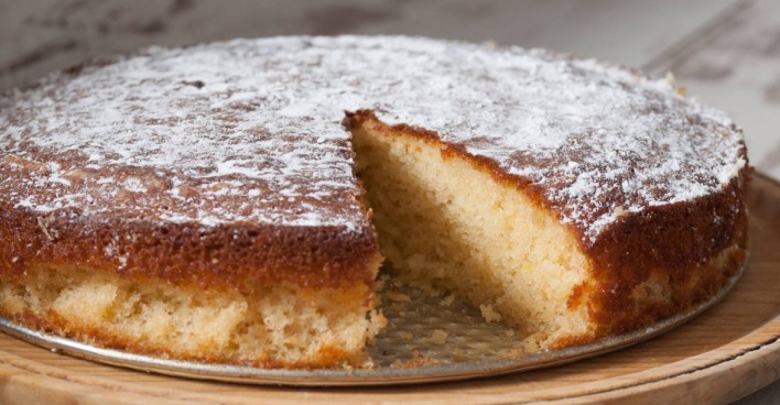 Angeschnittener Kuchen auf einem Servierteller, bei dem bereits ein Stück fehlt