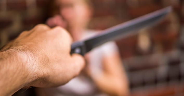 Ein Mann bedroht einen Frau mit dem Messer.