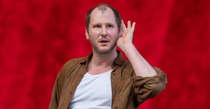 Marco Wanda auf der Bühne mit einem braunen Hemd und einem weißen T-Shirt.
