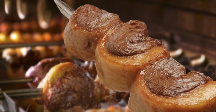 Spieß mit drei Stück Tafelspitz mit Fettdeckel über offener Flamme, gegrillt.