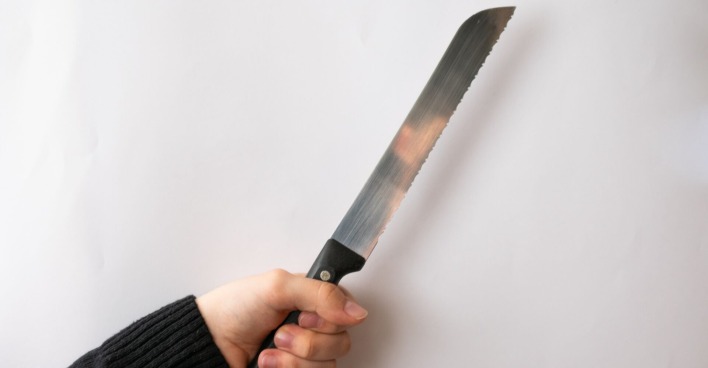 Eine Person hält ein Brotmesser in der Hand.