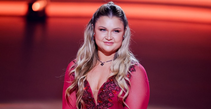 Sophia Thiel mit offenen gewellten Haaren und einem roten Kleid.
