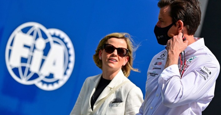 Susie und Toto Wolff vor dem Logo der FIA. Toto Wolff trägt eine Maske