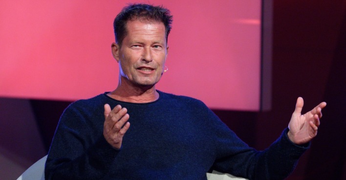 Till Schweiger sitzt bei einem Interview und gestikuliert mit den Händen